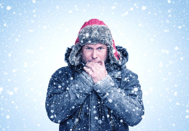 Homme gelé portant un vêtement chauffant qui se réchauffe les mains